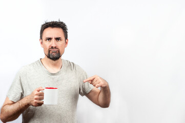 Dark-haired man in gray shirt; with expression of wanting coffee or tea