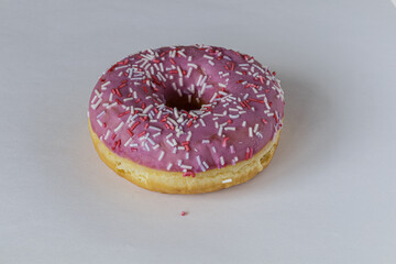 Tasty glazed raspberry donut with topping.