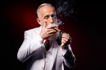 Photo of aged man smoke fume smoking cigarette addicted wear suit isolated over dark color background
