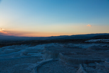 トルコ　ヒエラポリス・パムッカレの石灰棚と夕焼けでオレンジに染まった空