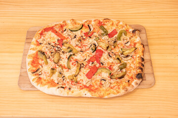 Rectangular Vegetable Pizza with Roasted Red Bell Pepper, Green Bell Pepper, Zucchini and Mushrooms Topped with Mozzarella Cheese and Tomato