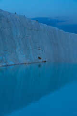 トルコ　夕暮れ時のヒエラポリス・パムッカレの石灰棚と青い水面
