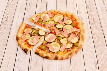 Vegan pizza with vegan mortadella simile, whole green olives, fried tomato, oregano, red onion and zucchini slices