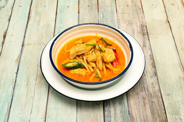Super spicy red chicken curry cooked with Thai recipe on enameled plate bowl