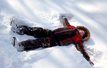 boy lying in the snow on a mountain