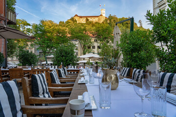 Fototapeta na wymiar All set table waiting for guests in a restaurant in Ljubljana with a nice view of the castle