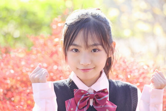紅葉バックの学生　ガッツポーズ