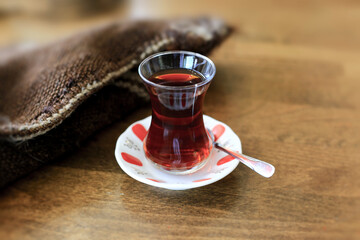 Traditional Turkish tea in original glass on wooden background.