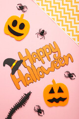 Halloween composition with spiders and pumpkins on pink background. View from above.