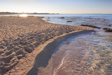 Relaxation on the beach at sunrise: Punta Prosciutto Beach in Puglia, southern Italy.