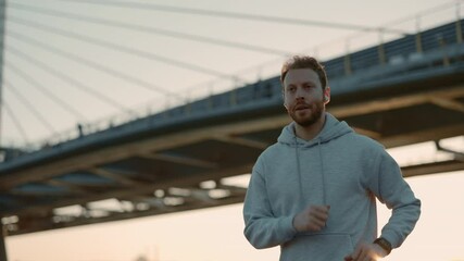 Male runner using earphone and fitness tracker outdoors