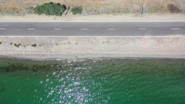 Aerial view Sevan lake near roadway.  Road runs parallel with a Sevan lake, Caucasus. aerial footage water near traffic way.