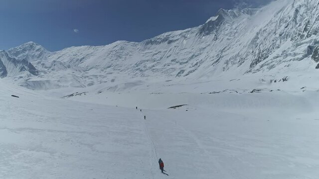 Tourists trekking at snow whiteness highlands near stunning Annapurna`s Grande Barrier and Tilicho Peak, Nepal