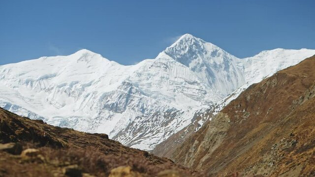 Huge snowy stunning out of reach summit of Annapurna massif at clear blue sky, Nepal