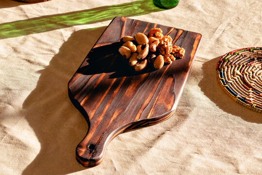 t&aacute;bua de corte com castanha brasileira sobre uma mesa na luz do sol