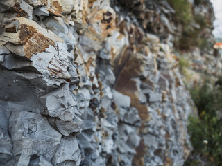 Texture of multi-colored mountain stones close-up. Side view. Stone background with blur. Geology. Pattern. Horizontally