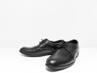 A pair of formal black shoes with laces displayed with white background
