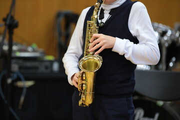 Boy college student playing saxophone at music lesson