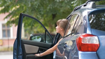 Woman driver getting out of her car and locking it with key fob while walking away on city street. Vehicle safety concept.