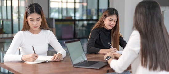 Young Asian college students have meetings with a teacher advisor or a tutor to discuss the project