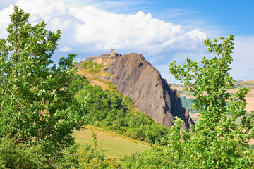 Scenic view of Pietra Perduca, an amazing volcanic rock with an ancient church set in stone immersed in a countryside landscape - Europe, Italy, Piacenza city, Bobbio, Val Trebbia