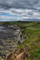 Fototapeta na wymiar landscape with sea and cliffs and a lighthouse in then distance. Taken in Yorkshire England. 