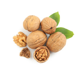 Pile of ripe walnuts and leaves on white background, top view