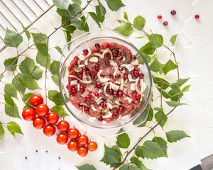 Summer food composition with marinated beef slices with onions, new crop seasonal vegetables on a grill. Cooking meat with farm vegetables in the open air. The concept of a picnic and healthy food