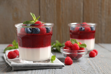Delicious panna cotta with berries on grey wooden table