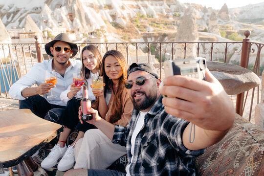 Smiling diverse friends taking selfie on photo camera