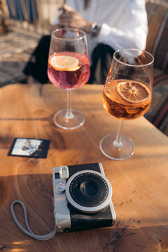 Camera with picture and glasses of drink on table