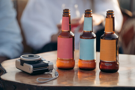 Row of glass bottles near instant photo camera on table