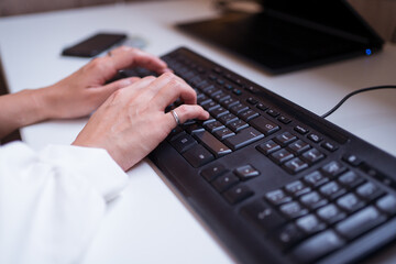 Anonymous female working typing on computer
