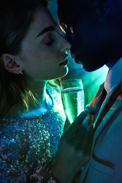 Crop romantic multiracial couple with champagne during New Years Eve