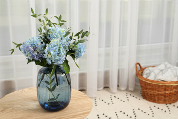 Beautiful blue hortensia flowers in vase on table indoors. Space for text