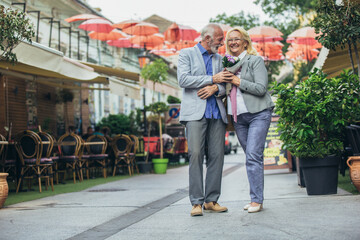 Fototapeta na wymiar Mature married couple are walking through a city together.