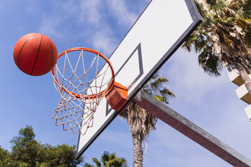 Basketball ball about to enter the basket.