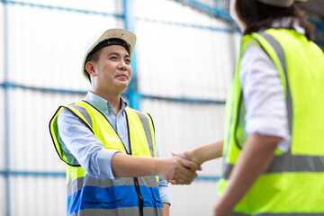Handshake. Engineering man shaking hand with professional engineer team at warehouse.