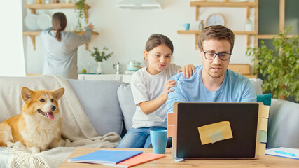 Social Distancing. A Busy Father Tries to Work Remotely with His Child and Wife at Home. The...