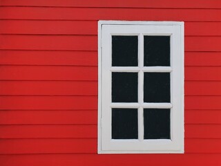 white window on red wooden wall