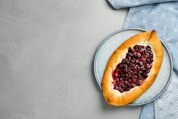 Delicious sweet cottage cheese pastry with cherry jam on grey table, top view. Space for text