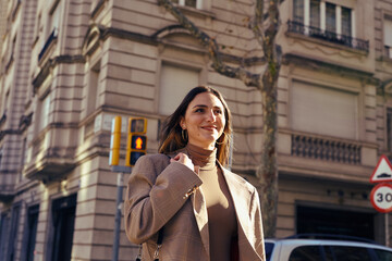 A blissful lady standing in the street smiling