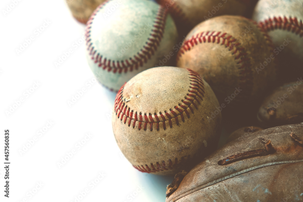 Poster old leather baseball glove with used balls from game with copy space on white background. - Posters