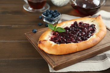 Delicious sweet cottage cheese pastry with cherry jam on wooden table. Space for text