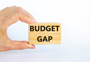 Budget gap symbol. Wooden blocks with words 'Budget gap'. Beautiful white background. Businessman hand. Business and budget gap concept. Copy space.