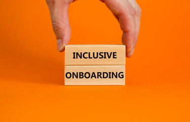 Inclusive onboarding symbol. Wooden blocks with words Inclusive onboarding on beautiful orange background. Businessman hand. Business, HR and inclusive onboarding concept. Copy space.