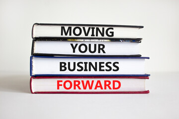 Moving your business forward symbol. Concept words 'Moving your business forward' on books on a...