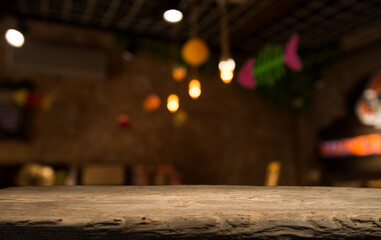 image of wooden table in front of abstract blurred background of restaurant lights