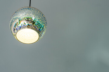 Modern chandelier in the shape of a ball on a gray background. Copy space