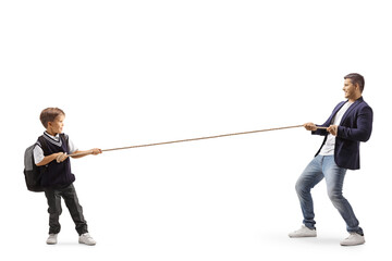 Full length profile shot of a little schoolboy and a young man pulling a rope